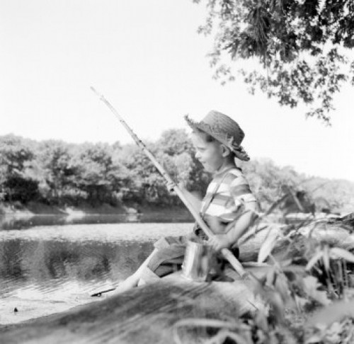 Boy sitting on riverbank and fishing Poster Print - Item # VARSAL255424547