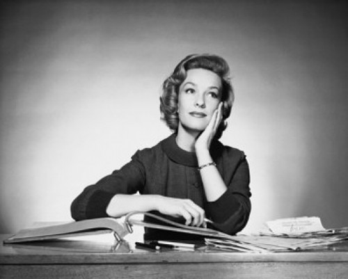 Businesswoman sitting at a desk in an office Poster Print - Item # VARSAL25515674