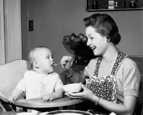 Mother feeding baby boy in high chair Poster Print - Item # VARSAL2559844