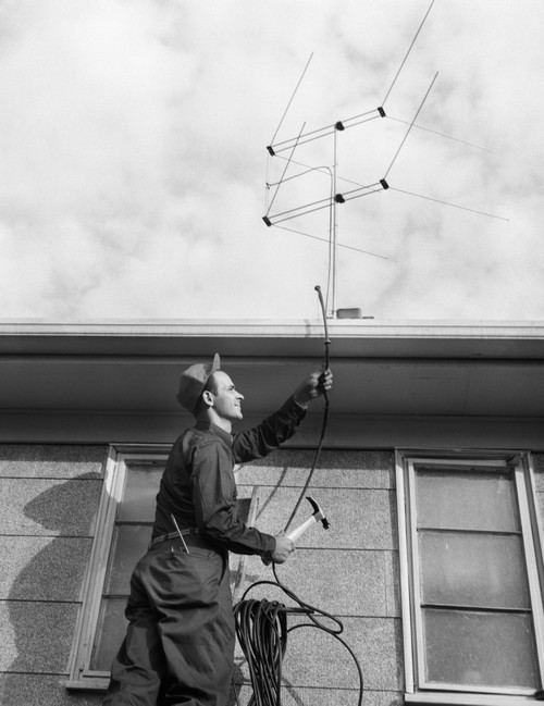 1950s-1960s Man Worker On Ladder Running Television Cable To Antenna On Roof Of House Print By Vintage Collection - Item # PPI178874LARGE