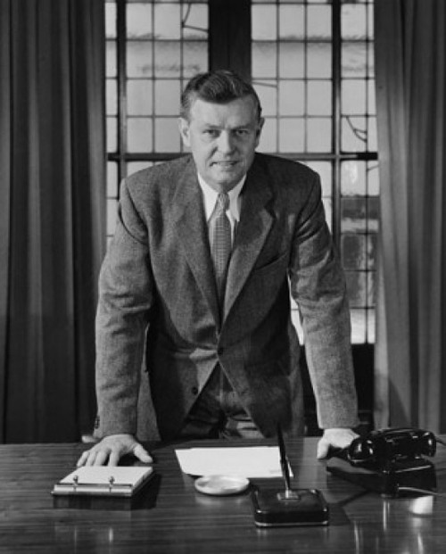 Businessman leaning against a desk in an office Poster Print - Item # VARSAL25548333