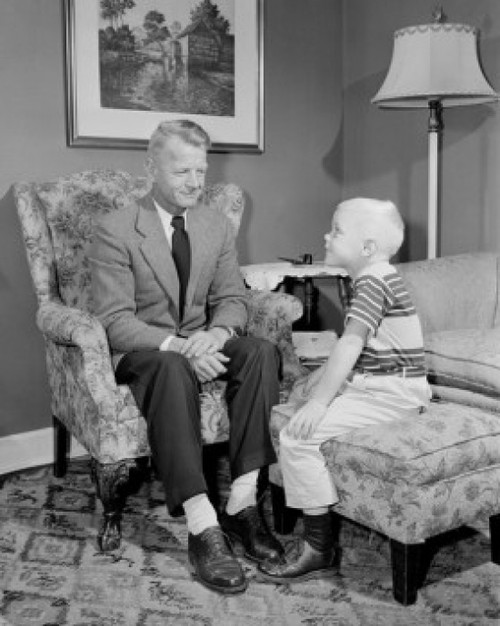 Boy sitting with grandfather in living room Poster Print - Item # VARSAL255422188