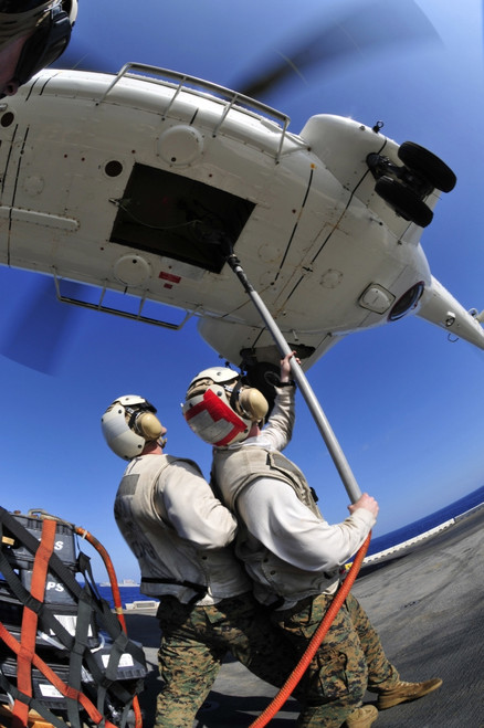 South China Sea, October 27, 2011 - Airmen attach pallet rigs to an SA-330J Puma helicopter abord the forward-deployed amphibious assault ship USS Essex during a replenishment at sea Poster Print - Item # VARPSTSTK104952M