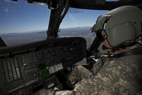 Pilot operating the cockpit of a UH-60 Black Hawk helicopter while en flight to Playas Training Area, New Mexico during exercise Angel Thunder 2013 Poster Print - Item # VARPSTTMO100977M