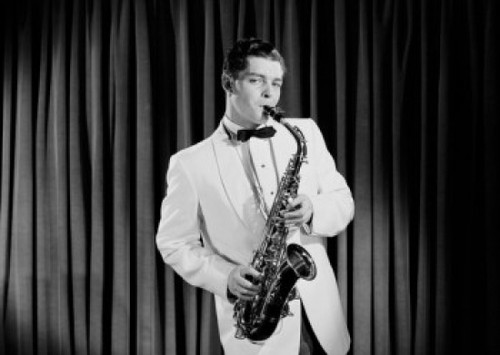 Portrait of young man playing saxophone on stage Poster Print - Item # VARSAL255420187