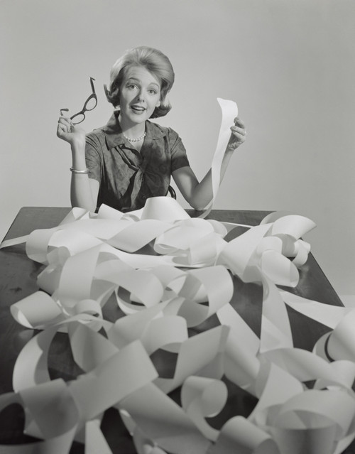 1960s Woman Holding Eyeglasses And End Of Extremely Long Tape From Office Adding Machine Looking At Camera Print By - Item # PPI179113LARGE