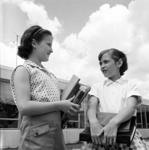 Two schoolgirls holding books and talking  low angle view Poster Print - Item # VARSAL255422136