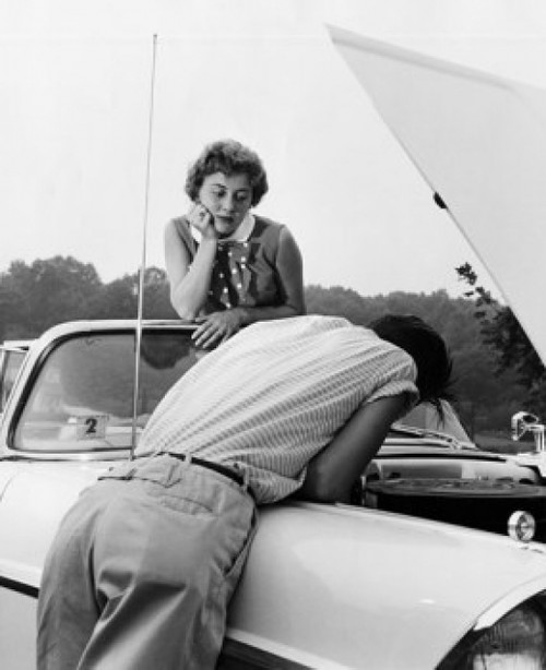 Rear view of a young man examining his car with a young woman looking at him Poster Print - Item # VARSAL2555557