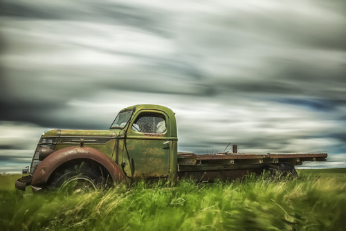 Long exposure of clouds drifting by over an abandoned truck; Saskatchewan, Canada PosterPrint - Item # VARDPI12254221