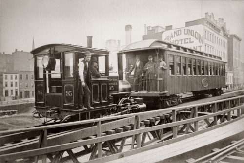 1880s Men On Board Elevated Locomotive & Passenger Car On East 42Nd Street Grand Union Hotel In Background New York City - Item # PPI195700LARGE