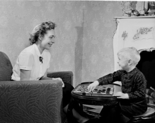 Boy playing draughts with mother in living room Poster Print - Item # VARSAL255422187