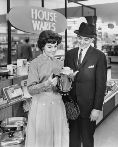Mid adult woman and a mature man looking at a kettle in a store Poster Print - Item # VARSAL2551455