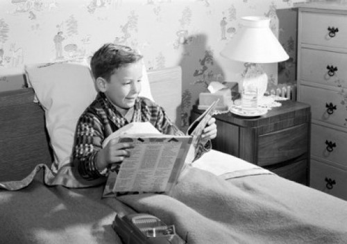 Boy sitting in bed  reading book Poster Print - Item # VARSAL255416328