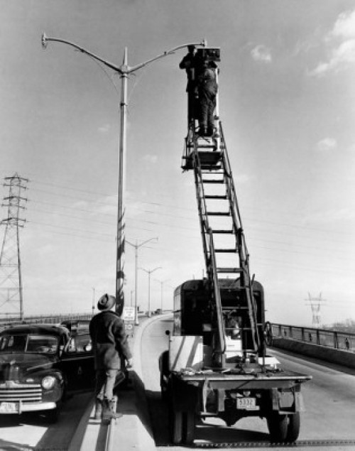 Low angle view of two men repairing street light Poster Print - Item # VARSAL25536892