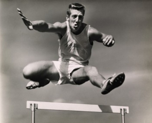 Low angle view of a male athlete jumping over a hurdle Poster Print - Item # VARSAL2553689