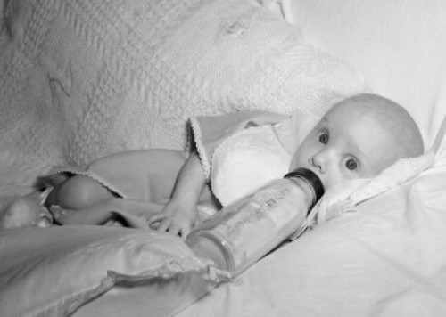 Baby with baby bottle on sofa Poster Print - Item # VARSAL2559675