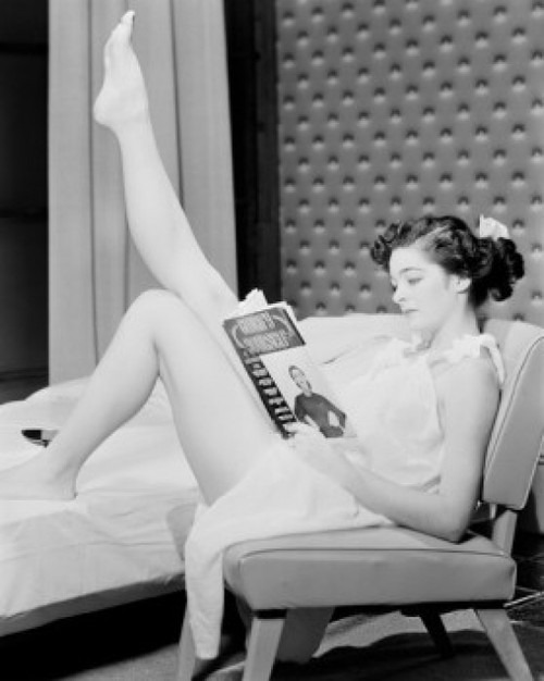 Young woman sitting and reading magazine Poster Print - Item # VARSAL255424614