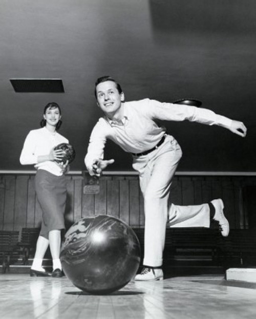 Young man bowling in a bowling alley with a young woman behind him Poster Print - Item # VARSAL25519756