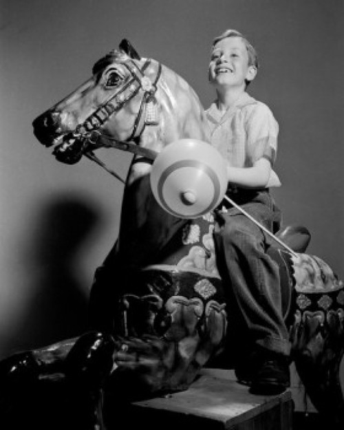 Boy riding on carousel Poster Print - Item # VARSAL255417010