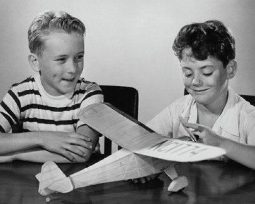 Boy making a model airplane and another boy sitting beside him Poster Print - Item # VARSAL25516523B