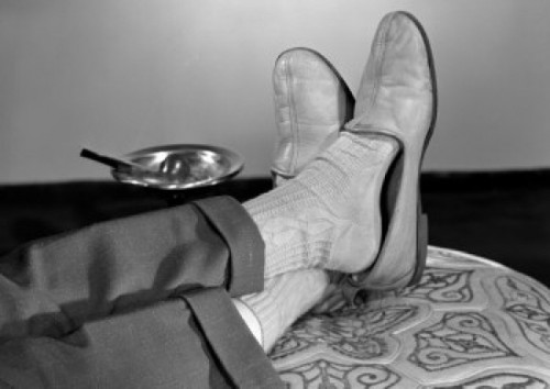 Low section of man relaxing with legs crossed at ankles Poster Print - Item # VARSAL25549326