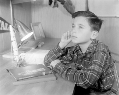 Boy sitting at desk with model missile Poster Print - Item # VARSAL255424645