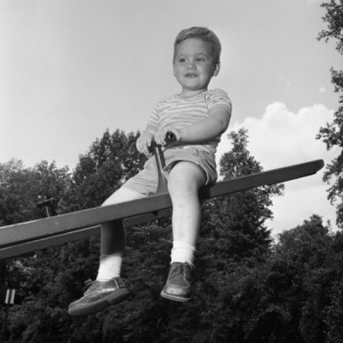 Boy sitting on seesaw and smiling Poster Print - Item # VARSAL255420847B