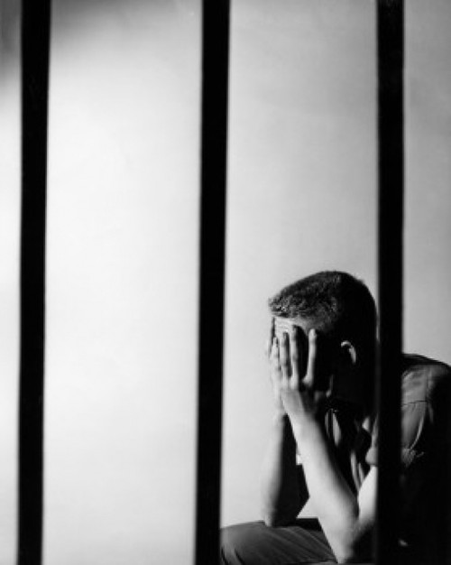 Male prisoner sitting in prison cell Poster Print - Item # VARSAL2557187