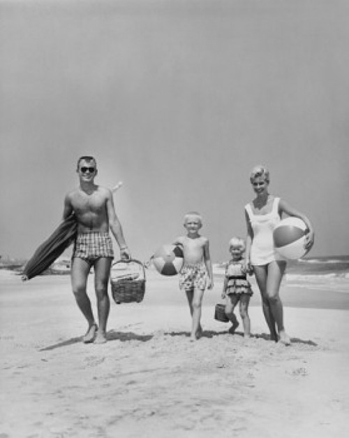 Parents with two children walking on beach Poster Print