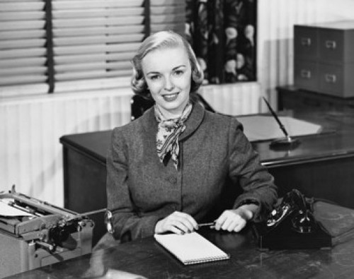 Portrait of a businesswoman sitting at a desk and smiling in an office Poster Print - Item # VARSAL25539183