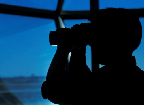 A Navy air traffic controller maintains an alert watch with binoculars in the control tower at Naval Air Station Millington, Tennessee Poster Print - Item # VARPSTWOD100001M