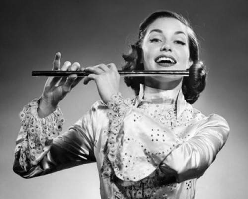 Young woman playing a flute and smiling Poster Print - Item # VARSAL25550136