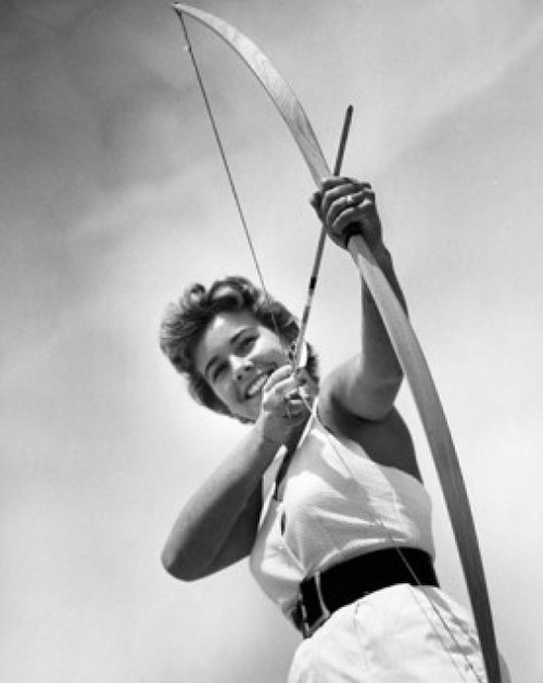 Low angle view of a young woman aiming with a bow and arrow Poster Print - Item # VARSAL25522446