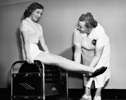 Young woman exercising on an exercising machine with the help of a female instructor Poster Print - Item # VARSAL25539189