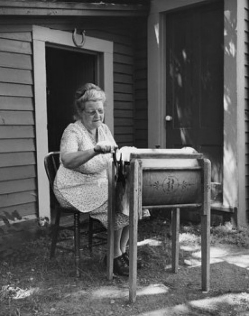 Senior woman churning butter in a butter churn Poster Print - Item # VARSAL25549051