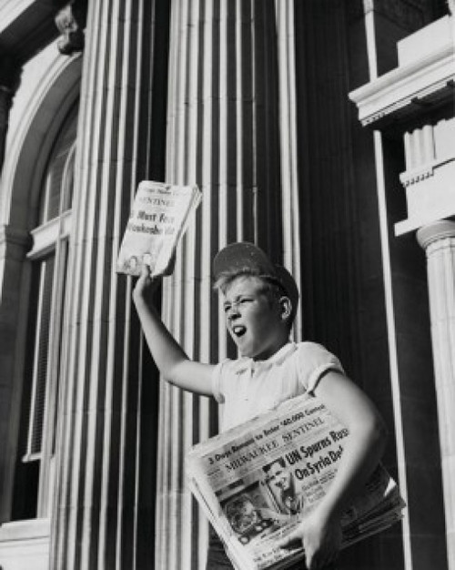 Boy selling newspaper in front of a building Poster Print - Item # VARSAL25536154