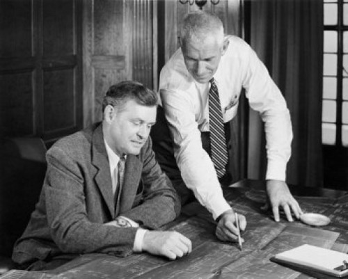 Two businessmen discussing blueprint in office Poster Print - Item # VARSAL25547975