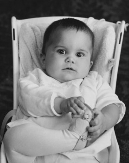 Baby girl sitting in a baby seat and holding her foot Poster Print - Item # VARSAL2559350B