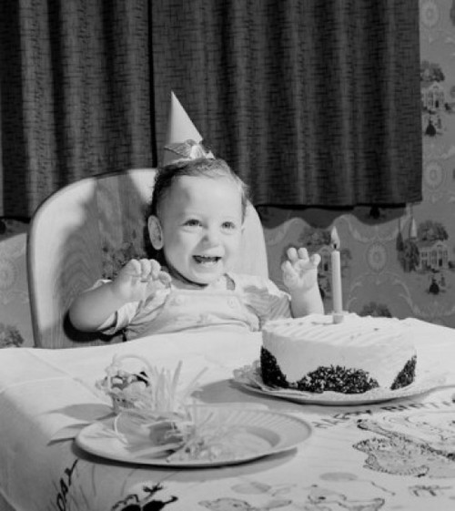 Boy sitting at table with birthday cake Poster Print
