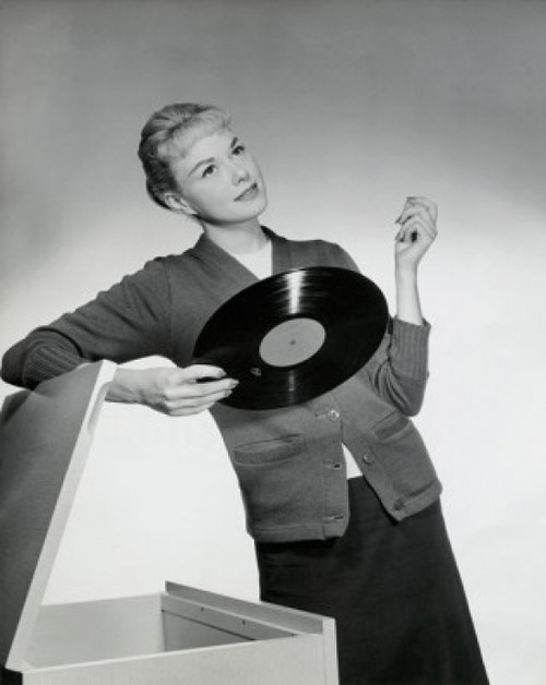 Close-up of a young woman leaning on a box and holding a record  1958 Poster Print - Item # VARSAL2554856