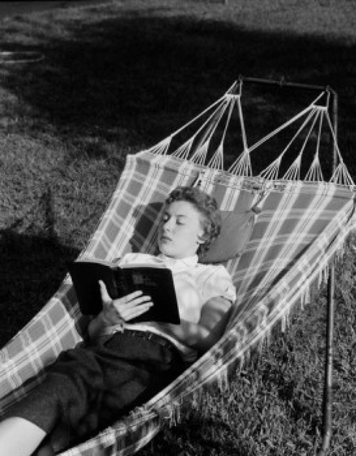Young woman lying in hammock and reading book Poster Print - Item # VARSAL255422125