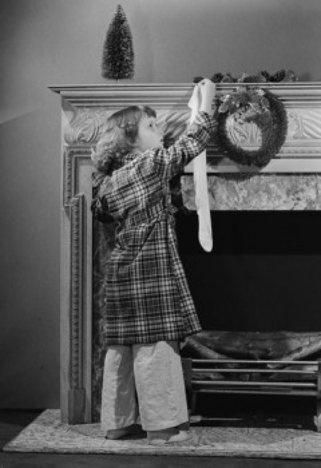 Girl hanging Christmas stocking on mantelpiece Poster Print - Item # VARSAL255422888