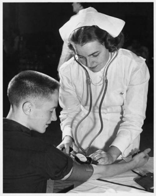 Female nurse checking a young man's blood pressure Poster Print - Item # VARSAL25515225