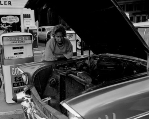 Mature woman leaning against car and looking  at car engine Poster Print - Item # VARSAL255416696