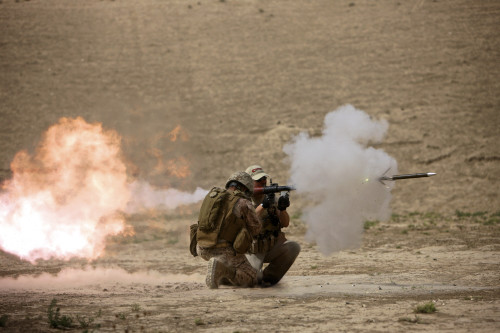 U.S. Marine watches a U.S. Contractor fire a HE fragmentation round from the RPG-7 rocket-propelled grenade launcher in a wadi near Kunduz, Afghanistan Poster Print - Item # VARPSTTMO100388M