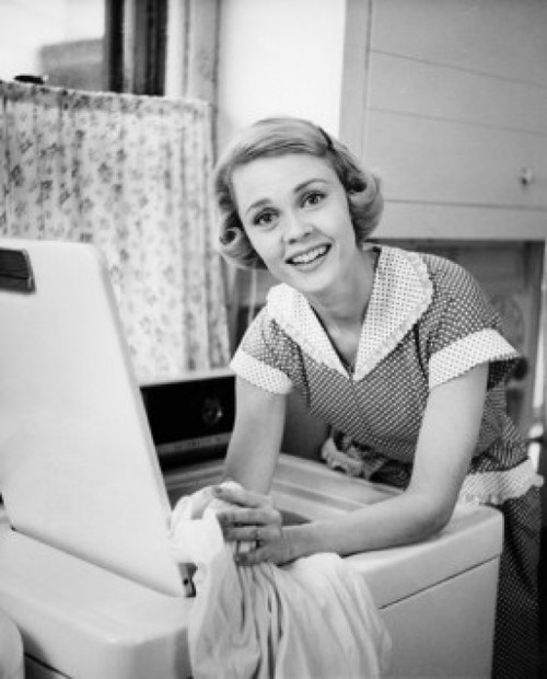 Portrait of young woman leaning on washing machine Poster Print - Item # VARSAL25541898