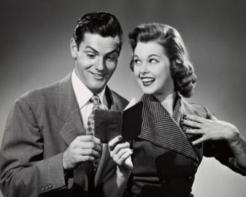 Young woman showing a bank book to a young man Poster Print - Item # VARSAL2552939