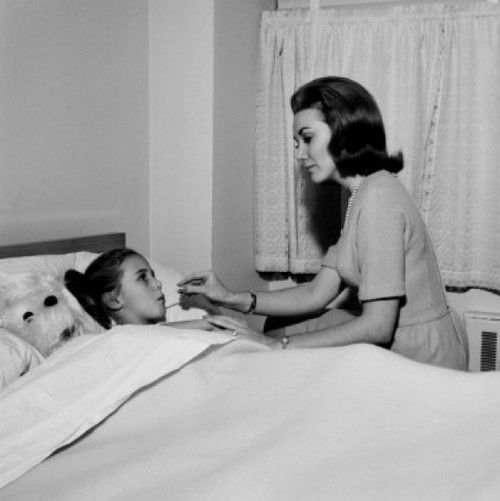 Mother checking daughter's temperature in bed Poster Print - Item # VARSAL255417753
