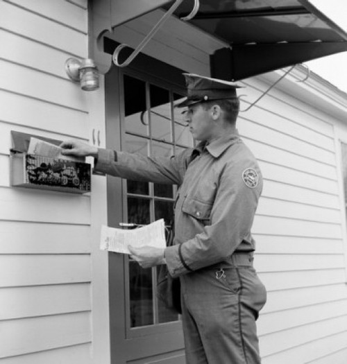 Side profile of a postman dropping mail in a mailbox Poster Print - Item # VARSAL2559064