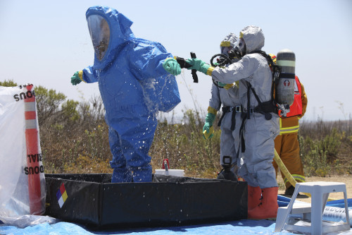 An airman stands in a tub of cleaning solution during a decontamination process Poster Print - Item # VARPSTSTK104029M